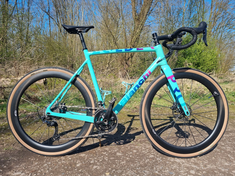 Een celeste Bianchi Zolder Pro gravelbike uitgerust met hoge GreenGrav FLN-50 carbon wielen en brede skinwall gravelbanden
